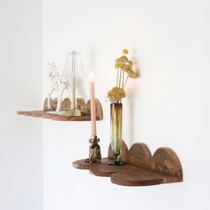 two wooden shelves with flowers and candles on them