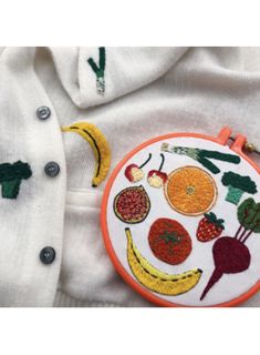 an embroidered shirt with fruits and vegetables on it