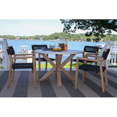 a table and chairs on a deck overlooking the water