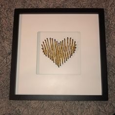 there is a framed picture with sticks in the shape of a heart