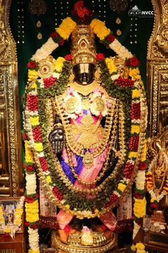 the statue is decorated with flowers and garlands