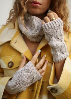 a woman in a yellow coat is holding her hands together