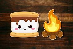 a toasted marshmallow next to a campfire on a wooden table with wood planks