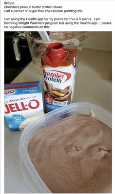 a plastic container filled with chocolate pudding next to a carton of jello