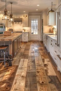 a kitchen filled with lots of white cabinets and counter top next to a wooden floor