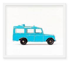 a blue toy truck sitting on top of snow covered ground in front of a white background