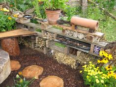 a wooden bench sitting in the middle of a garden filled with lots of plants and flowers