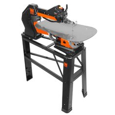 an orange and black table saw sits on top of a metal workbench with one foot resting on it