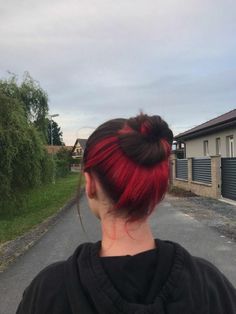 a woman with red hair standing in the middle of an empty road and looking back