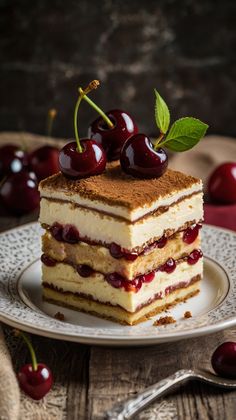 a piece of cake on a plate with cherries