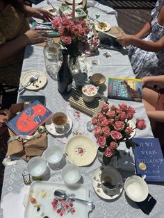 people sitting at a table with plates and flowers