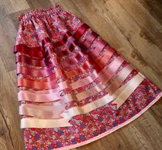 This unique Couture Ribbon Skirt with matching side fringe features 2 XL concealed pockets, Red MMIW "Heal" Jackie Traverse Ojibway Floral Print design and is made from 100% premium cotton for maximum comfort. Length is 33 inches. Buyer decides the custom waist up to 55 inches for a perfect fit. Includes 7 Ruby, Blush and Cream-coloured ribbons, thread which is carefully color-matched, while professional seams ensure durability. With a delicate satin bias hem and paper-bag waist and 1.5 inch non Ojibway Floral, Ribbon Clothing, Side Fringe, Cozy Wrap