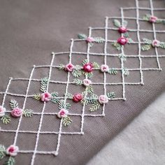 a close up of a piece of cloth with pink flowers on it and green leaves