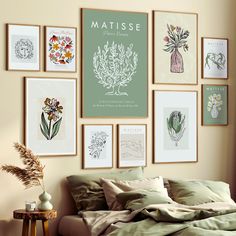 a bed with green sheets and pictures hanging on the wall above it in a bedroom