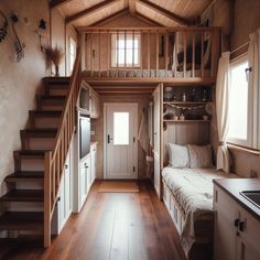 the interior of a tiny house with stairs leading up to the bedroom and kitchen area