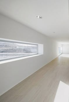 an empty room with white walls and wood flooring is seen in this image from the inside