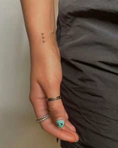 a woman's hand with a small tattoo on it