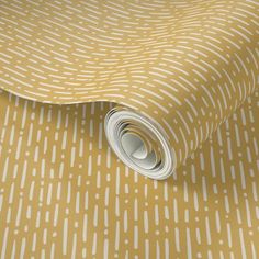 a yellow and white polka dot wallpaper with a roll of paper on top of it