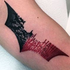 a batman tattoo on the arm with red and black ink that says happy birthday to you