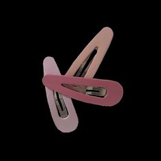 three pink and white hair clips on top of each other in the shape of two spirals