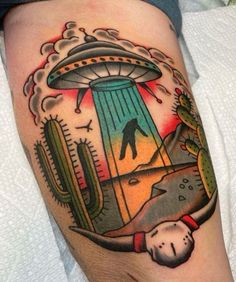 a tattoo on the leg of a person with an alien ship in the sky above them