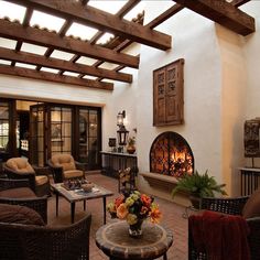 a living room filled with furniture and a fire place in the middle of a building