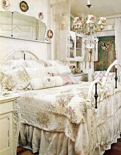 a white bed sitting in a bedroom next to a dresser and mirror on top of a wooden floor