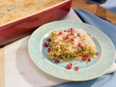 a casserole dish with cranberries on it next to a blue and white plate