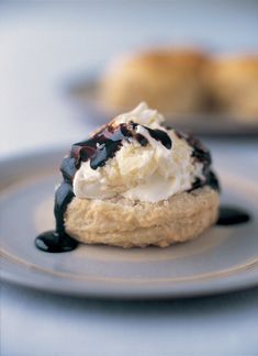 an ice cream sundae on a plate with chocolate sauce and whipped cream drizzled over it