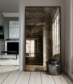 an open door leading into a room with white walls and wood flooring in it