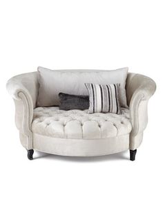 a white chair with two pillows on it