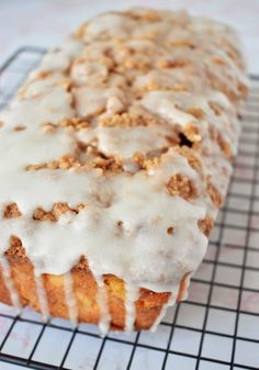 a close up of a muffin on a cooling rack with icing and crumbs