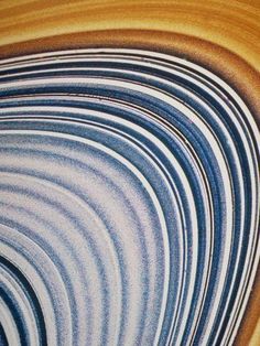 an abstract painting with blue and brown stripes in the shape of a spiral on wood