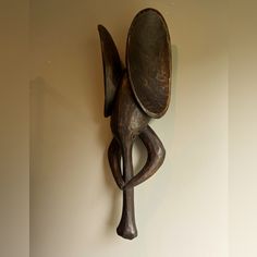 a wooden sculpture hanging from the side of a wall