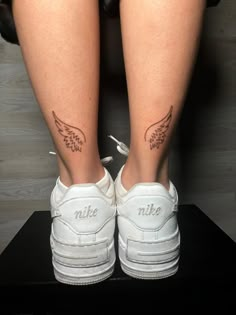 a woman's legs with tattoos on them and white shoes in front of her