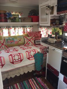 a kitchen area with a bed, stove and sink in it's centerpiece