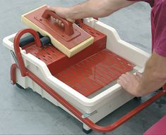 a person using a red and white cleaning machine