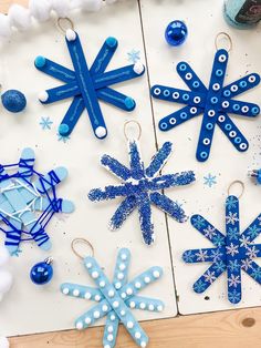 paper snowflakes and ornaments are on the table next to some glue beads