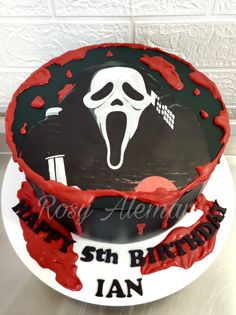 a birthday cake decorated to look like a screamy face with red and black icing