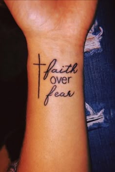 a wrist tattoo with the words faith over fear on it