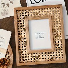 a wooden frame sitting on top of a table next to some papers and pine cones