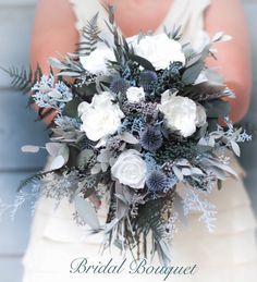 a bride holding a bouquet of white and blue flowers