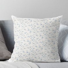 a white and blue pillow sitting on top of a couch