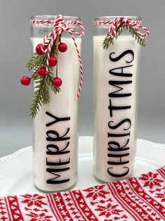 two christmas candles sitting on top of a white plate