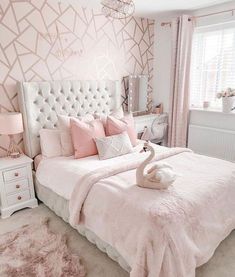 a bedroom decorated in pink and white with a large headboard on the wall next to a bed