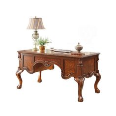 an antique desk with a lamp and potted plant on it's end table