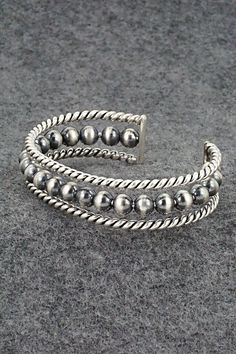 This darkened sterling silver bracelet featuring a row of round beads was made by Navajo silversmith Elaine Tahe.Size: 5 1/8" (will fit up to a 6 1/4" wrist)Gap: 1 1/8"Width: 1/2"Free shipping on all orders! We ship with USPS and always include tracking. All orders ship within a day of payment.Returns are accepted up to 30 days after you receive your order. Just send us a message. Our shop offers cash back or store credit. The item must be returned in new condition. Southwestern Style Silver Bracelets With Round Beads, Southwestern Style Silver Bracelet With Round Beads, Southwestern Silver Bracelet With Round Beads, Adjustable Southwestern Silver Bangle, Nickel-free Bohemian Sterling Silver Bracelet With Round Beads, Southwestern Style Nickel-free Bangle, Bohemian Sterling Silver Hand-strung Bracelet, Southwestern Silver Hand-strung Bracelets, Sterling Silver Bracelet