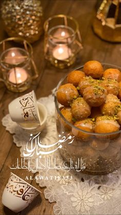 a bowl filled with food on top of a table next to candles and tea lights