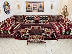 an elaborately designed couch in a living room with white walls and flooring, along with decorative rugs