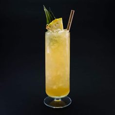 a tall glass filled with a yellow drink